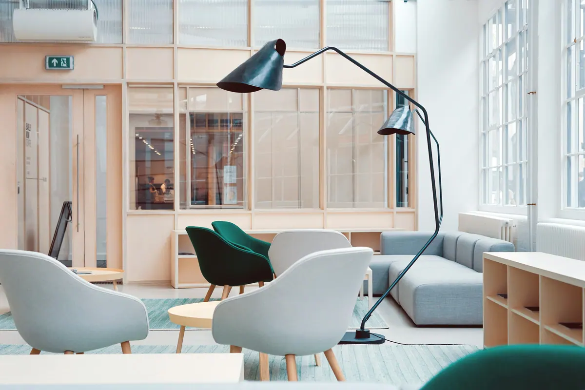 Lounge corporativo com estantes baixas e poltronas