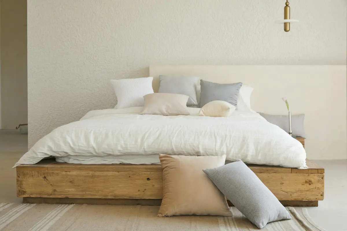 Suíte com cama em madeira maciça e enxoval claro