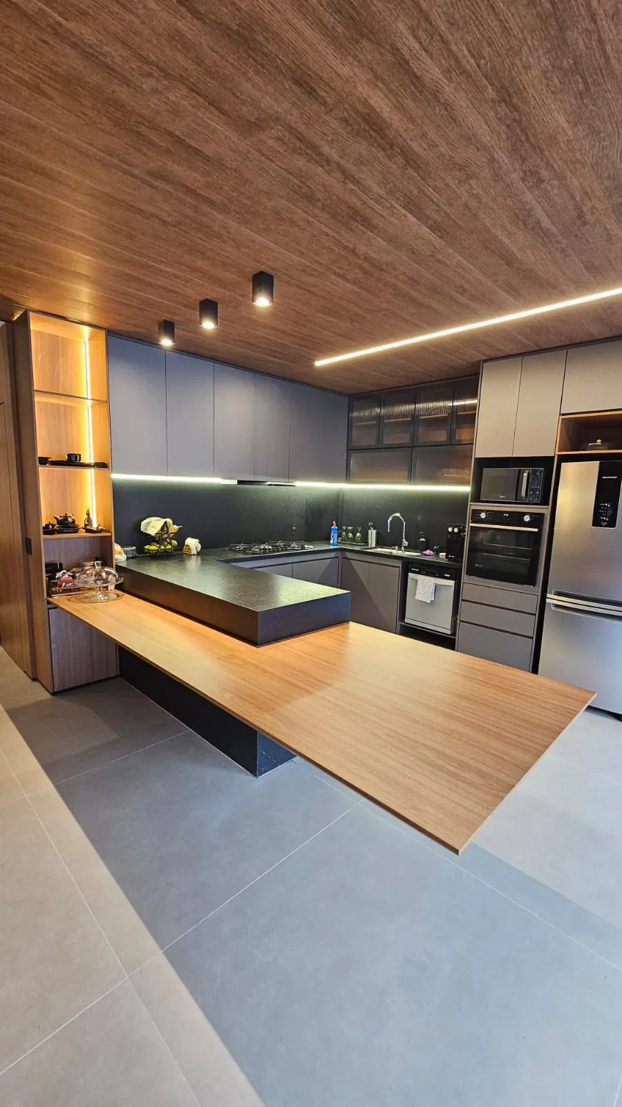 Cozinha integrada com forro amadeirado: Cozinha + estar integrado