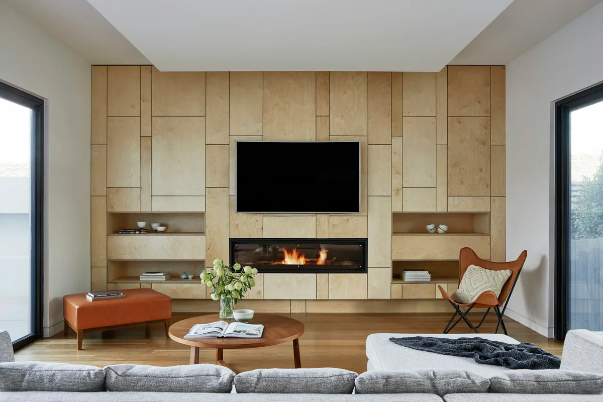 Sala com painel modular em madeira e nichos laterais
